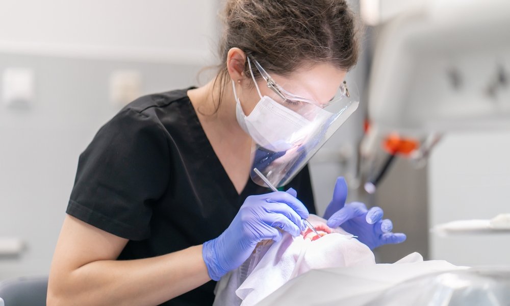 Medic stomatolog consultă un pacient
